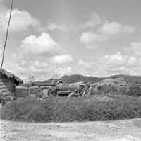"Ashau-Laos Border", houses in a middle of a tall grass field (solder hiding in there?)