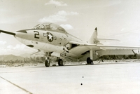"The TF9J 'Cougar' is a single engine, two seat aircraft utilized as a tactical airborne coordinator." A US Marine Corps jet sitting in an airfield.
