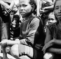 Original caption: "Montagnards - Showplace Strat. Ham - 8-21-62 - In MTs - Faces - Blockhouses" A group of Montagnard women crouching.