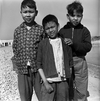"Macau" Three young boys pose for a photogragh together.