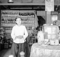 A Vietnamese woman standing in a shop or restaurant.