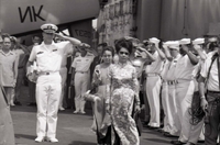 Nguyá»…n Thá»‹ Mai Anh and another Vietnamese woman walk past a group of saluting American officers and sailors. They are onboard a US Navy 7th Fleet ship.