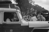 "Embassy Bombing" A crowd of people in the street. Two men in an ambulance attempt to drive around them.