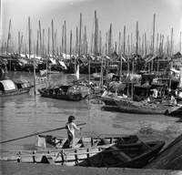 "Macau" A young boy is on a boat in the foreground.