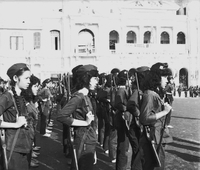 Original caption: "Mne. Nhu + Paramilit. Graduation - 27 Feb 63" A formation of Vietnamese women as they hold gund on their backs.