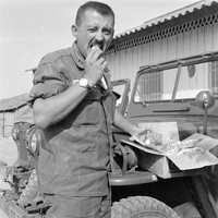 Original title "Cao Lanh - XON + MAAG ", a man (police officer) standing next to a car, appear to be doing some paper work