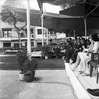 Original caption: "Mne. Nhu + Paramilit. Graduation - 27 Feb 63" Madame Nhu (Tran Le Xuan) is sitting on stage - people are seen sitting behind her.