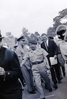 Robert McNamara walks behind Nguyá»…n KhÃ¡nh in a crowd.