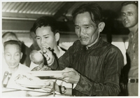 "South Vietnamese guests sample American food for the first time while visiting Naval Mobile Construction Battalion EIGHT at Chu Lai to express appreciation for construction work done in their province by the American Seabees." Vietnamese man stands in line being served American food for the first time. Seabees news release 170-67 (55).