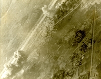 "Explosions - Kep airfield, 37 miles northeast of Hanoi, as explosions blasted the runway a daylight strike by Navy jets from attack carrier USS Kitty Hawk." Aerial photo of clouds rising from bombed buildings.