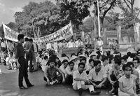"Students wrecking min. of info." A long line of students in the street. Some are sitting. Some stand and hold up a large banner.