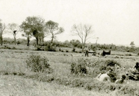 American soldiers setting up a camp in an open field.