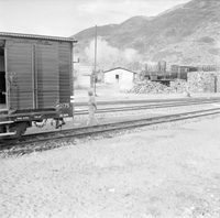 "QN + Train ", picture of a railroad, houses in the background, part of atrain on the side (?)