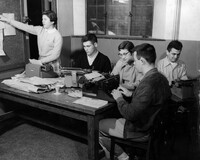 University of Nebraska Lincoln Journalism students, 1956. This photo was taken as a promotional photo for the department. Keever sits in the center of the photo writing on a typewriter
