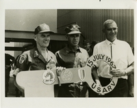 Original title: "'Key' to the Army 'Palmer House.'"  "Rear Admiral Spencer R. Smith, CEC, USN, center, gives Army Lieutenant General Bruce C. Palmer, left, a huge, symbolic key to his new $5 million headquarters complex being built by the Navy at Long Binh, South Vietnam. Rear Admiral Smith as Deputy Commander Pacific Division, Southeast Asia and Officer in Charge of Construction, Republic of Vietnam, for the Naval Facilities Engineering Command (NAVFAC) directs the civilian contractor, RMK-BRJ, (represented by General Manager Jim Lilly, at right.) This year NAVFAC is observing its 125th anniversary." Giant key is presented to Seabees. Seabees news release 18-67 (48).