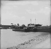 "Ca Mau" Several boats are sitting near the shore docked in the water.