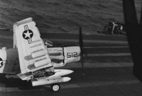 "7th Fleet" A Naval plane on an aircraft carrier. The wings of the plane are detached and folded.