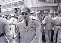 A Vietnamese military officer standing in front of many other military personnel, both American and Vietnamese.
