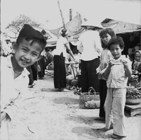 "Ca Mau" Market with several young children are in the foreground.