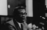 "Huong." Trần Văn Hương sitting in front of a microphone.