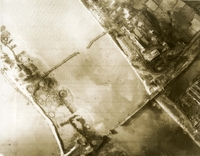 "Pre and post Strike Navy Photography of Kien An Highway Bridge - with the carrier striking force in the Tonkin gulf, Mar. 16 - Shown is the Kien An highway bridge on the southern edge of Haiphong after being severed by 1,000-pound bombs dropped by Navy A4 Skyhawks from the aircraft carrier USS Kitty Hawk. The 658-foot bridge , which links Haiphong with Ninh Binh/Nam Dinh area of North Vietnam, was severed by Navy pilots of Attack Squadrons 144 and 112, led by Cdr. N. Duff Arnold, 40, of San Diego, a Carrier Air Wing 11 pilot." An aerial photograph of a bombed river. There are two cut bridges and craters on the river's shore.