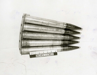 "During the week of 28 Apr., U.S. Forces fighting in the A Shau valley have captured various Soviet-built weapons and components from the North Vietnamese. The sophistication of these captured weapons and the fire power that they represent pose a definite threat to allied forces. In addition, the recovery of these items reflects the continued support of the North Vietnamese, by the Soviet Union. Soviet 37mm M1939 antiaircraft ammunition. The Soviet 37mm AA Gun Fires a 1.6 pound projectile to a maximum AA range of 20,000 feet. The gun uses an optional fire control, manual tracking and elevation, and closely resembles the U.S. 40mm AA Gun of WWII vintage. The projectile is equipped with a point detonating, contact type fuse with a self-destruct element. There is no capability for regulating the height of the burst. This photograph shows a clip holding five rounds." A clip of ammunition rounds.
