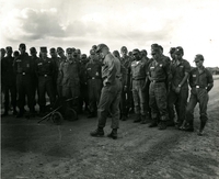 "Bien Hoa, Vietnam (IO) - General Harold K. Johnson, U.S Army Chief of Staff, talks to men of the Army's 2nd Bn, 1st Infantry Division at Bien Hoa - The 1st Div. was one of several units visited by General Johnson during his visit to Vietnam. Weapon in foreground is a Chinese Machine Gun captured by the 173rd." A group of American soldiers stand around a machine gun.