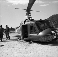 A downed Army helicopter - two American soldiers standing to the left.
