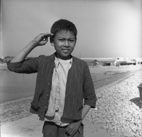 "Macau" One boy poses for a photo. He solutes the camera.