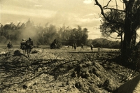 "Operation 'Malheur II' - Paratroopers of the U.S. Army's 1st Brigade, 101st Airborne Division, shoot and scoot across the open field near Duc Pho in southern Quang Ngai Province, as enemy troops hidden in the tree line snipe at the advancing infantryman. The 'Screaming Eagles' of the 101st are one of three U.S. Army brigades operating in the northern provinces as part of Task Force 'Oregon.' The airborne unit's sweep has been named Operation 'Malheur II.'" American soldiers run through a field away from the camera.
