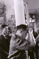 Nguyá»…n KhÃ¡nh attending a funeral. He is holding burning candles above his head.
