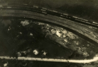 "Devastated - said Navy jet pilots of Carrier Air Wing 15, Sep. 21, 1966, after pounding a railroad ferry complex northeast of Thanh Hoa in North Vietnam. The accompanying before-and-after photos display partial effects of about 200 tons of bombs dropped during the day by Air Wing 15. In attacking the area at least 8 defending flak sites were silenced. Boxcars, tracks and bomb craters are clearly seen before-and-after being hit by A6 Intruder and A4 Skyhawk pilots." Aerial photography of a road and trains on a railroad.