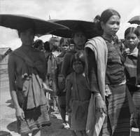"Montagnards - Showplace Strat. Ham - 8-21-62 - In MTs - Faces - Blockhouses" Villagers carrying umbrellas.