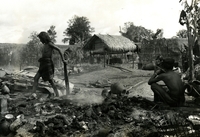 A hamlet in the background, with some villagers walking around in the foreground.