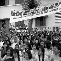 A crowd of young women - a banner is being held above them.
