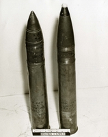 "During the week of 28 Apr., U.S. Forces fighting in this A Shau valley have captured various Soviet-built weapons and components from the North Vietnamese. The sophistication of these captured weapons and the increase in fire power that they represent pose a definite increase in threat to allied forces. In addition, the recovery of these items reflect the continued support of North Vietnam by the Soviet Union. Ammunition of Soviet 76mm Guns. This Soviet 76mm ammunition can be fired from the Soviet 76mm M1942 Field gun or from the 76mm Tank Gun mounted on the Soviet PT-76 Amphibious Tank. The photograph shows two rounds, One HE and the other APHC-T (Armor Piercing High Explosive-Tracer)." Two explosives.