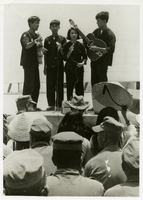 "To help the people of Bob Sinh Province in South Vietnam show their appreciation for the construction work done by the Navy Seabees in their behalf, this Vietnamese singing group performs at Chu Lai for U.S. Naval Mobile Construction Battalion EIGHT. The singers travel throughout South Vietnam encouraging their people to fight communism and often exposing themselves to Viet Cong terrorism." Vietnamese singing group performs for the Seabees. Two hold guitars. Seabees news release 170-67 (55).