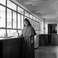"Macau" Photo of a nun standing in a kitchen, smiling at the camera.