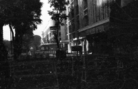 A Vietnamese city street that is blocked off with fencing and barrels.