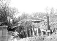 Original caption: Salt Creek bridge West of penitentiary showing damaged barricade and paving. Apr. 16, 1922
