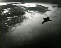 "A U.S. Navy F-8 'Crusader' leaves the flight deck of the USS Bon Homme Richard (CVA-31) At dawn, for a strike mission against North Vietnam." Air plane flying through cloud.