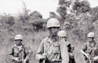 Four American soldiers standing in a field.