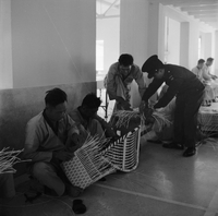 "Ai Lam - HK*" Several men weaving baskets, near the background a man in uniform lends a hand.