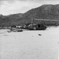 An Army helicopter has crashed, with part of its tail laying next to it.