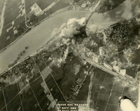 "Before and After near Thanh Hoa, North Vietnam - Navy jet pilots of Carrier Air Wing 15 pounded a railroad ferry complex northeast of Thanh Hoa Sep. 21-23, 1966. Targets included a thermal power plant, defending flak sites, railways, boxcars, and roads. After the raid shown in these before and after photos, Navy Intruder and Skyhawk pilots described the area as 'devastated.'" Aerial photo of a bombing of a railway bridge in a rural area.