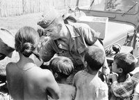 An American soldier named Hibbs is handing out supplies to villagers.