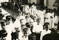 "Vietnamese Orphans receive congratulations from Lieutenant Colonel Paul C. Smithey, commander of the 52nd Combat Aviation Battalion, on the dedication of the Tu Tam Orphanage at Pleiku recently. The orphanage is sponsored by the men of the 52nd." A large crowd of Vietnamese children stand and look at the camera. The girls and boys are in separate groups. There is an American soldier and a Catholic nun with the children.