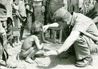 A Vietnamese child is having their hair trimmed by an American soldier named "Hibbs" who holds a cigarette in the other hand.