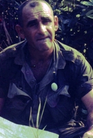 An American soldier sitting down and looking at the camera.