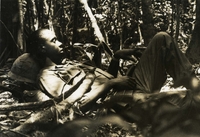 "Khanh Duong, Vietnam - After cutting his way through thick jungle on a search and destroy mission all day, SSgt. Sylvester Bowman (Philadelphia, Pa.) takes a few moments out for rest during opening phases of Operation Summerall. The operation, which began March 30, sent 1st Brigade, 101st Airborne Paratroopers into the central highlands of Khanh Hoa Province to search out the enemy." A soldier lays on the floor of the forest.